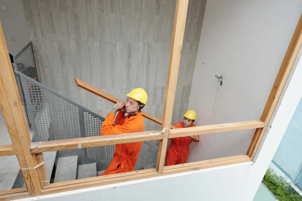 Builders carrying timber showcase the about us commitment of Deck Builders Palmerston North.